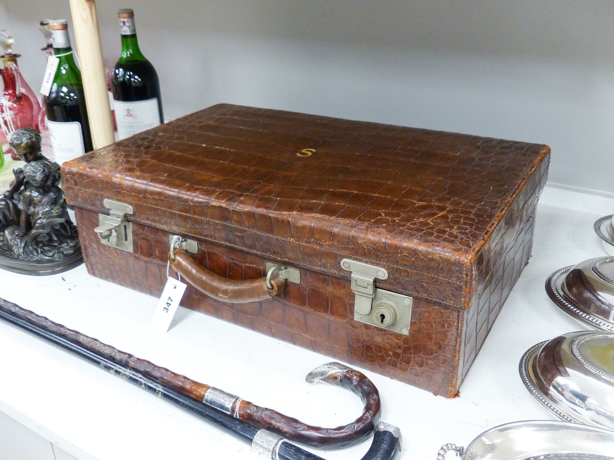 An early 20th century crocodile skin suitcase with blue leather lined interior 61cm